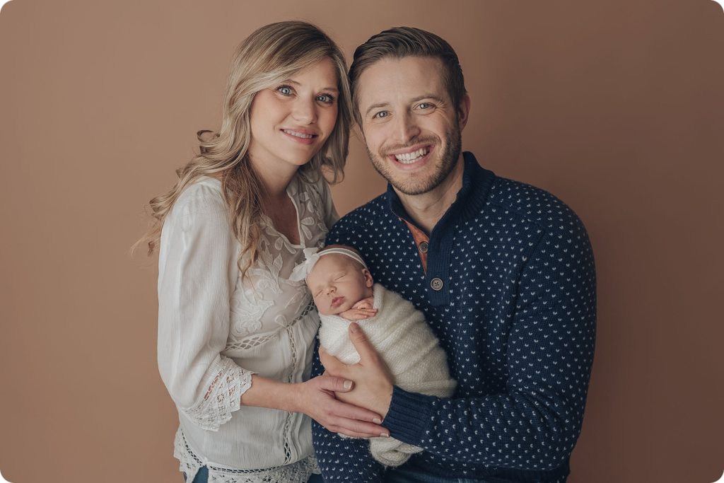 new parents hold baby girl during Utah newborn portraits with Beka Price Photography