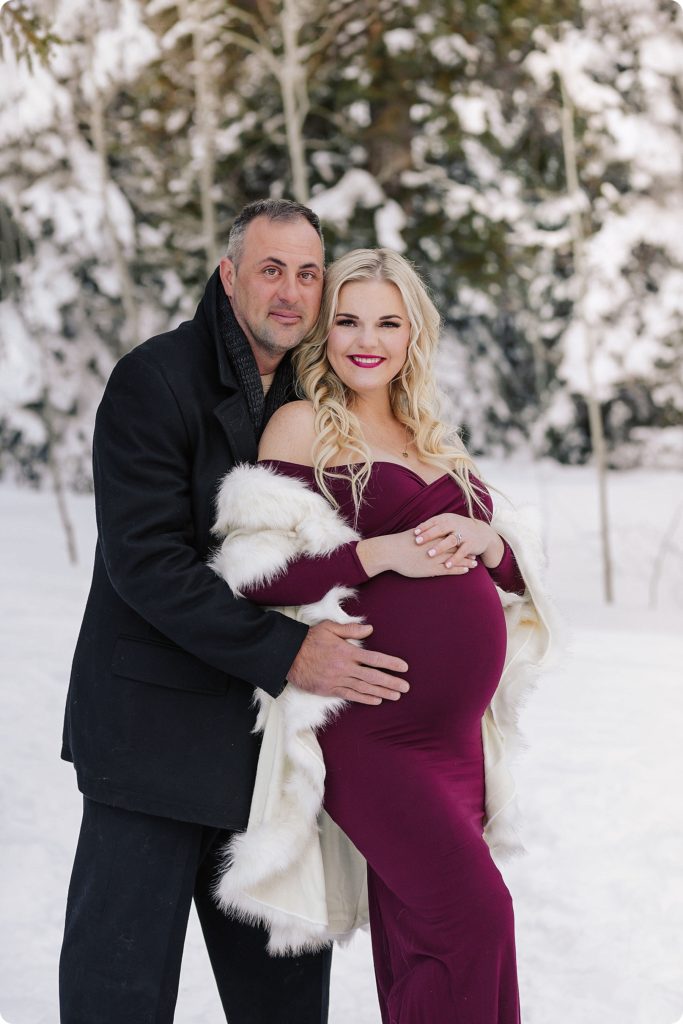 Beka Price Photography photographs husband and wife during snowy maternity session in Utah