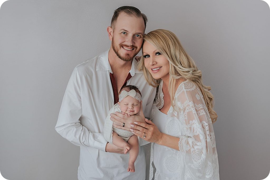 family of three smiles with newborn baby at Beka Price Photography