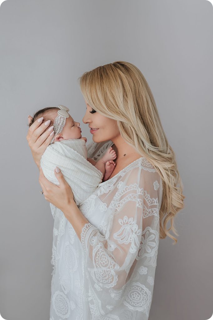 mom holds baby girl in nursery