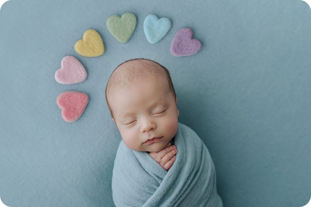 baby with rainbow hearts above head during newborn session