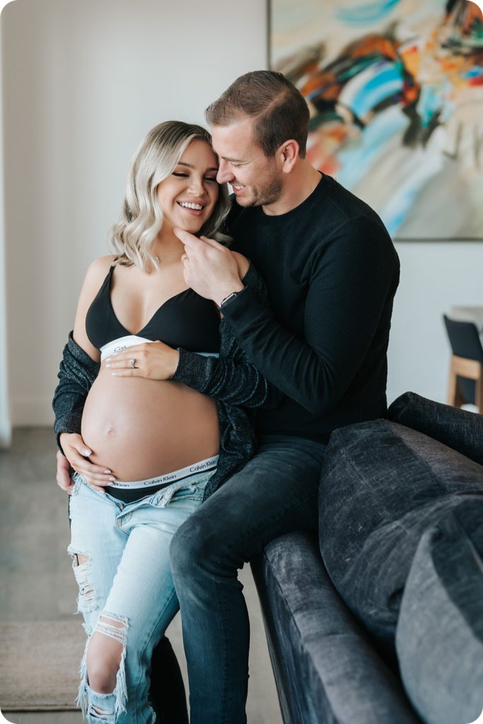 expectant parents laugh together during high fashion maternity photos