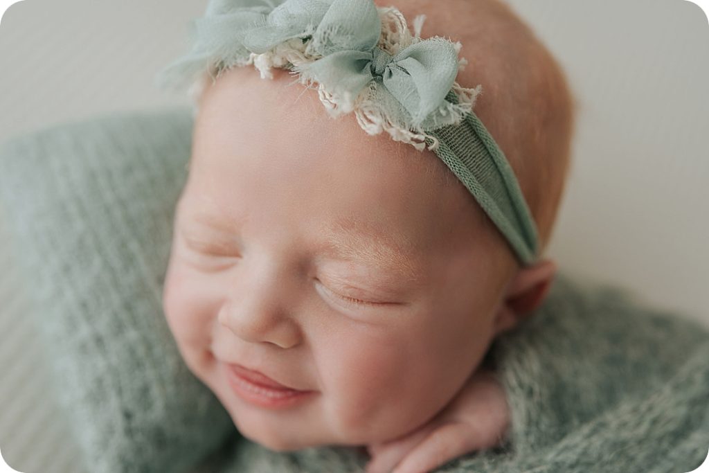 baby girl smiles during Holladay UT newborn portraits