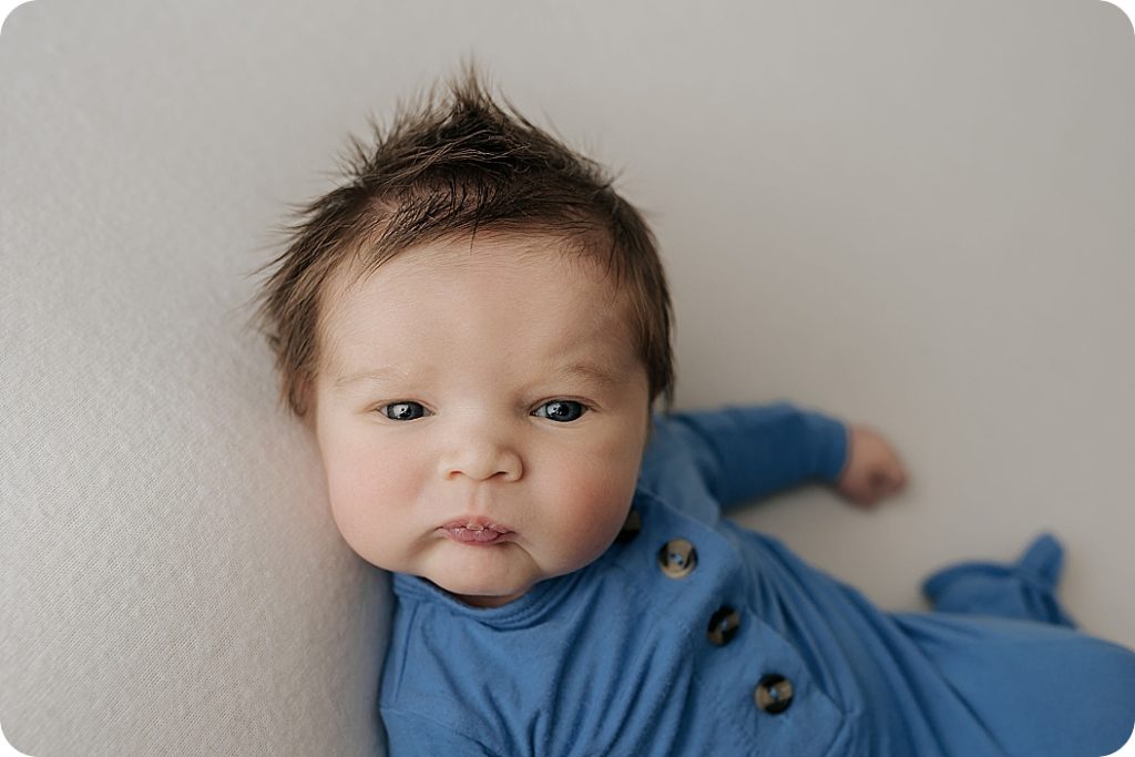 baby boy in blue outfit posed by Utah newborn photographer Beka Price Photography
