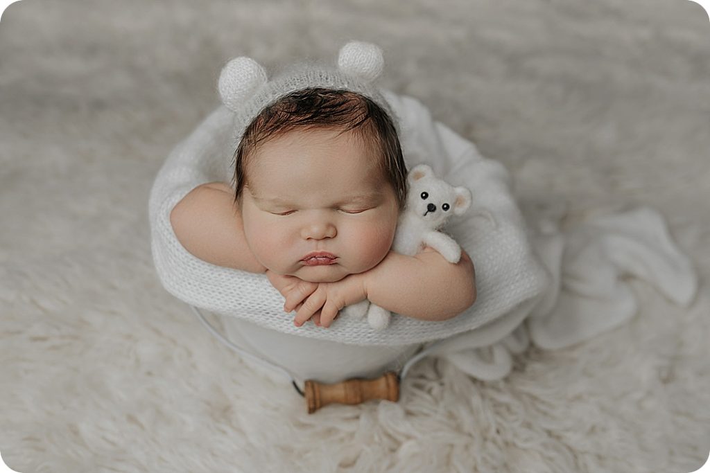 classic newborn session with baby in white bear bonnet