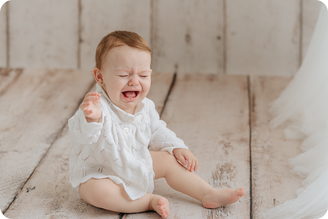 baby cries during classic first birthday milestone portraits in Utah studio 