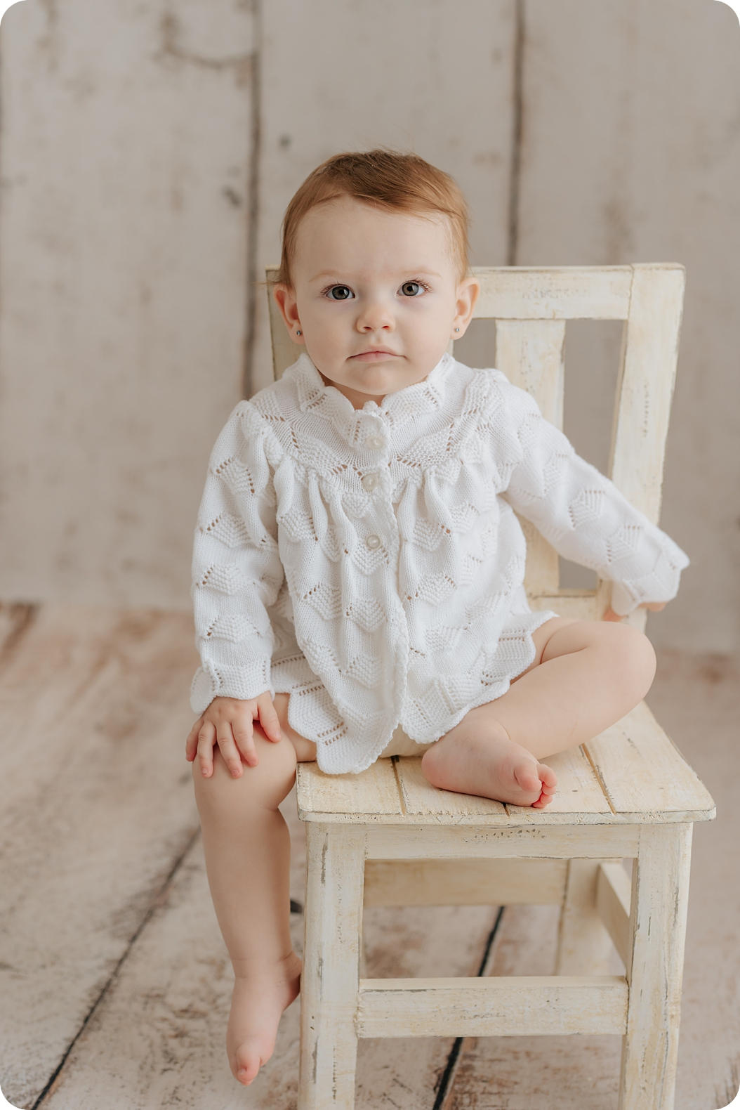 toddler sits on chair during neutral milestone portraits in Utah studio