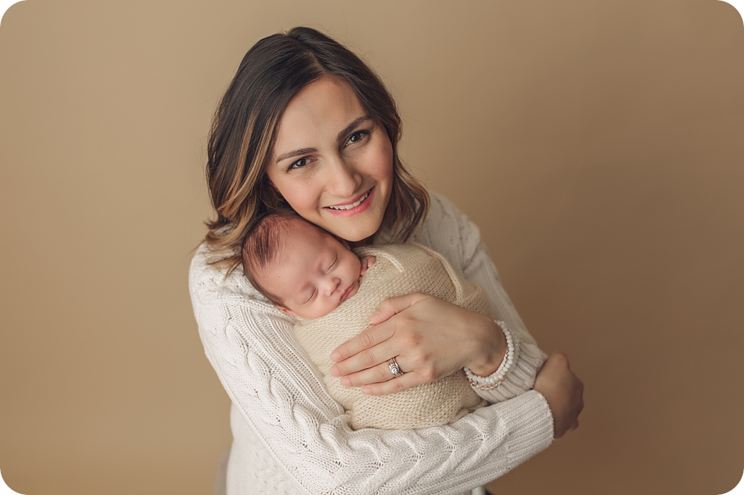 mom holds baby boy during Utah newborn portraits