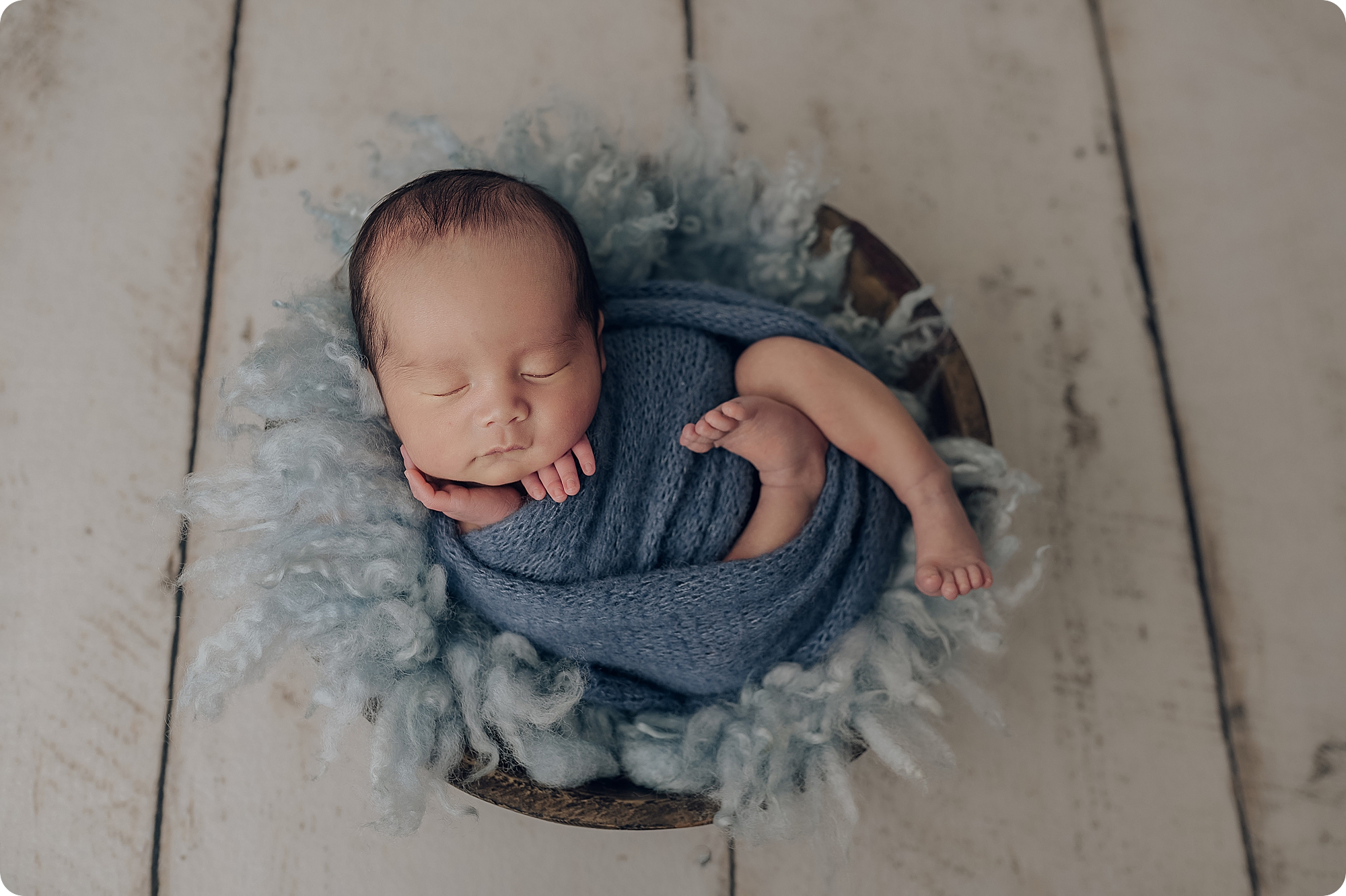 baby boy in basket with blue wrap and blue floki during Classic Studio Newborn Session