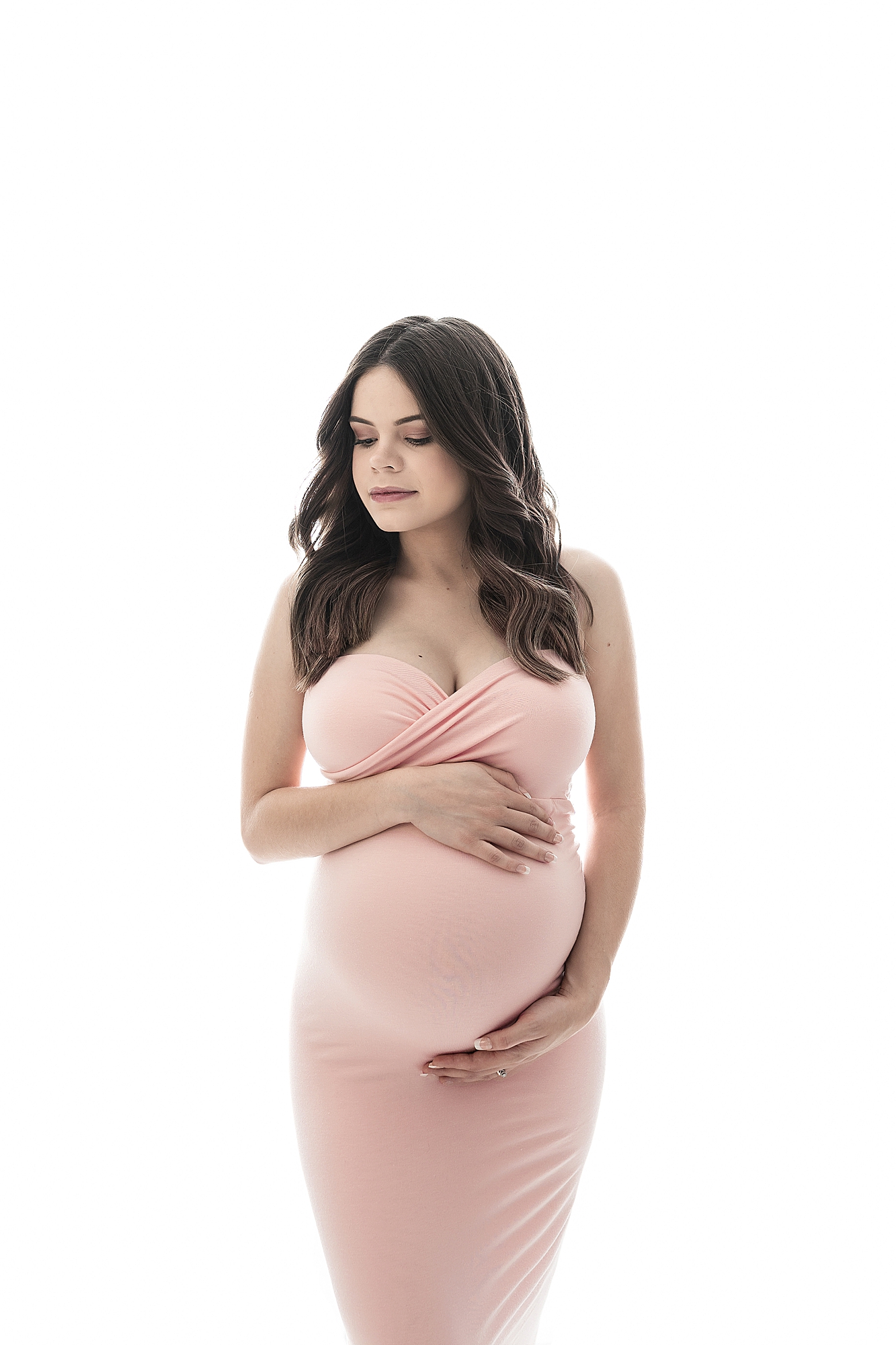 mom holds baby belly wearing pink gown in studio with Beka Price Photography