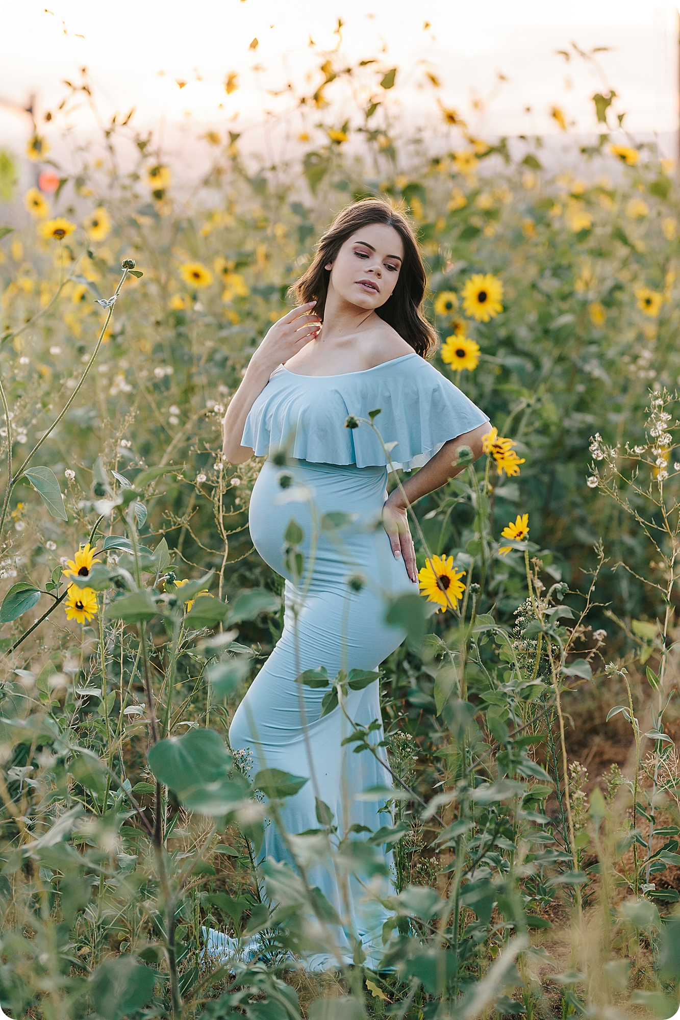 mom poses in sunflower field during Fall Maternity Portraits