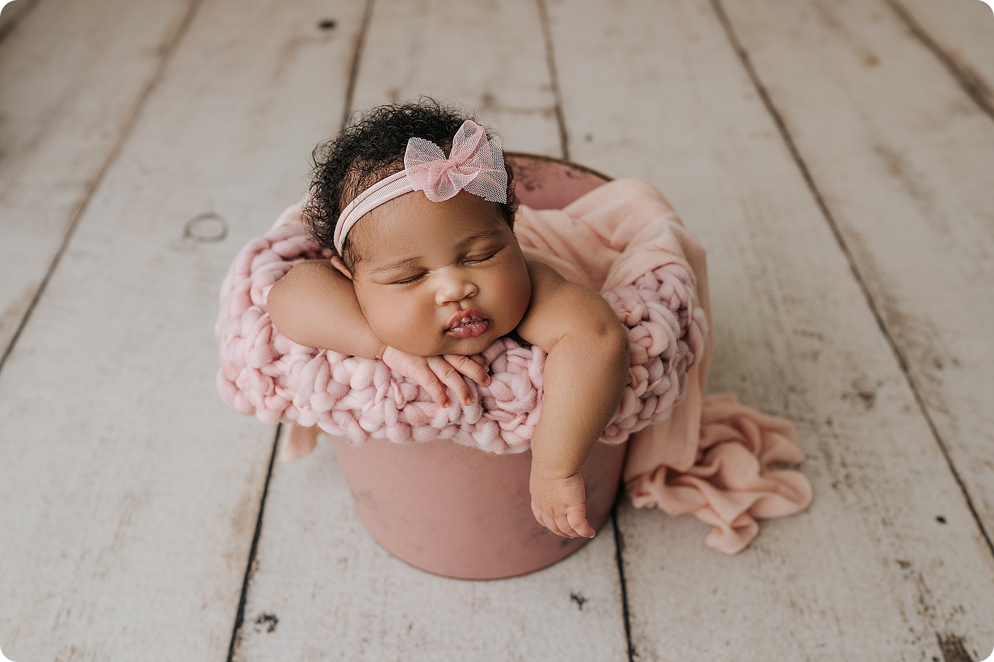 baby girl in pastel pink bucket sleeps photographed by UT newborn photographer 