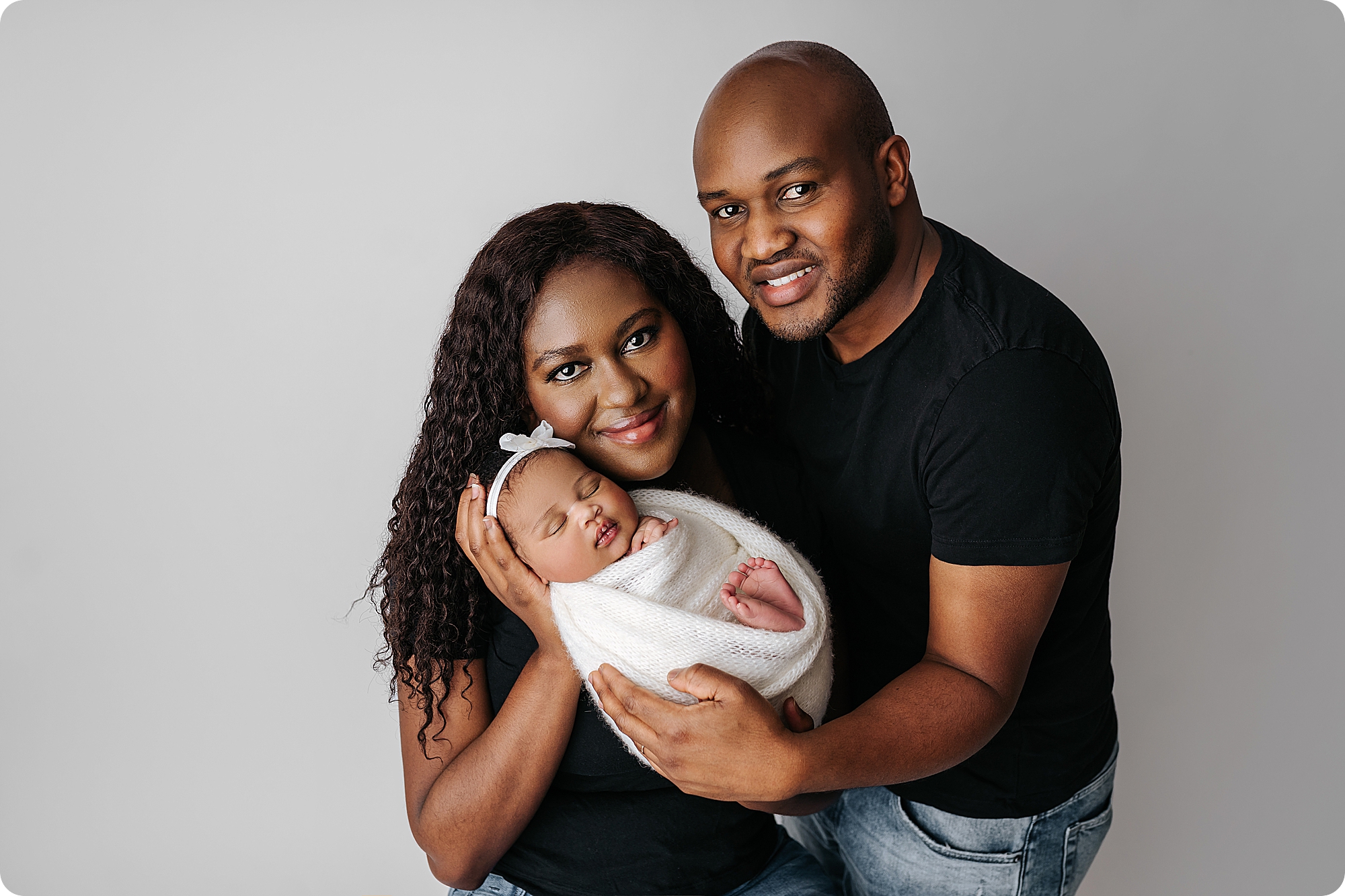 parents snuggle baby girl during Timeless Studio Newborn Portraits with Beka Price Photography