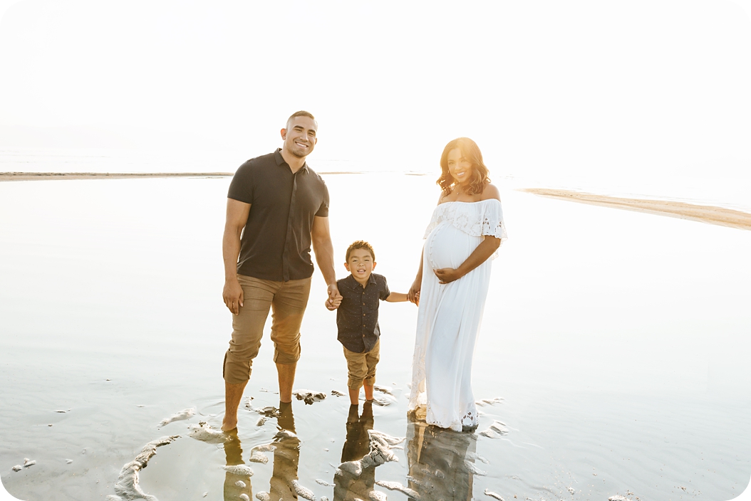 family poses in Utah lake during maternity photos with Beka Price Photography