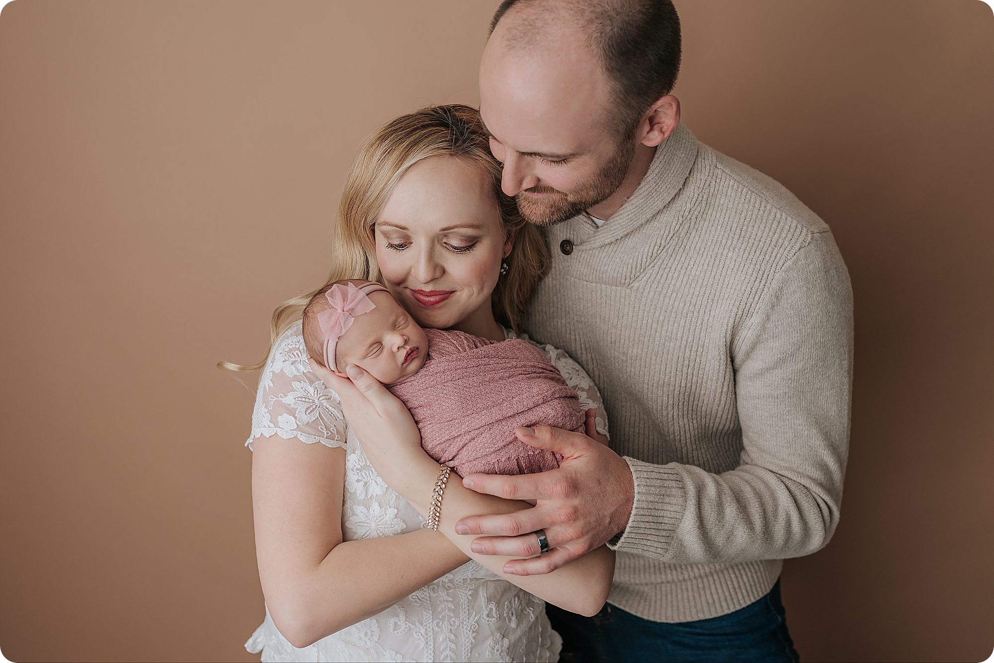 parents snuggle newborn baby girl in Beka Price Photography's studio