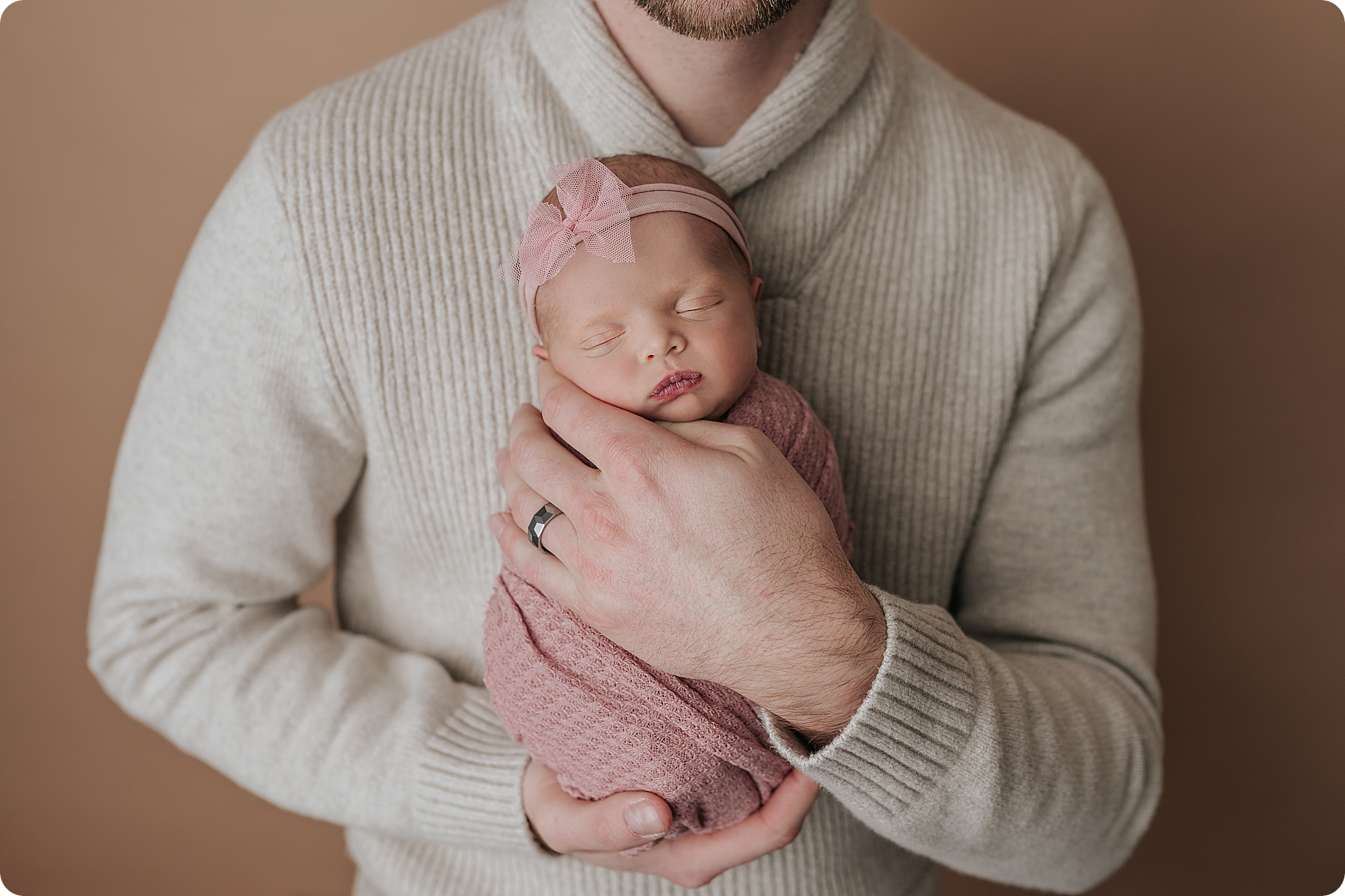 dad holds baby girl during cozy studio newborn portraits in Utah studio