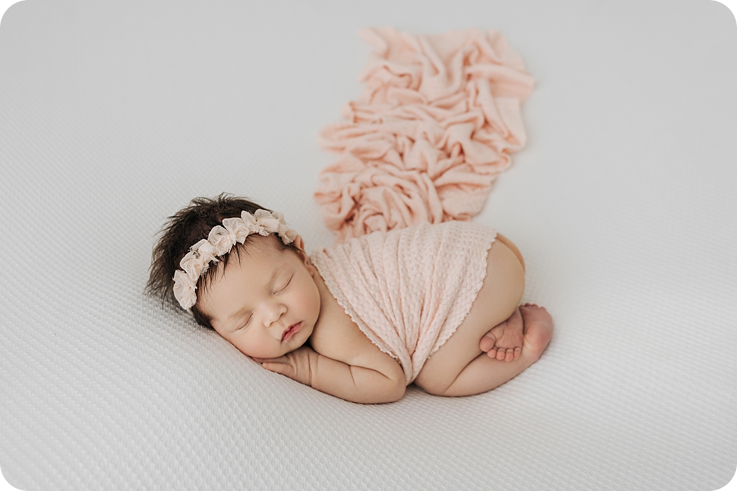 baby girl sleeps in peach wrap during simple newborn session with Beka Price Photography 