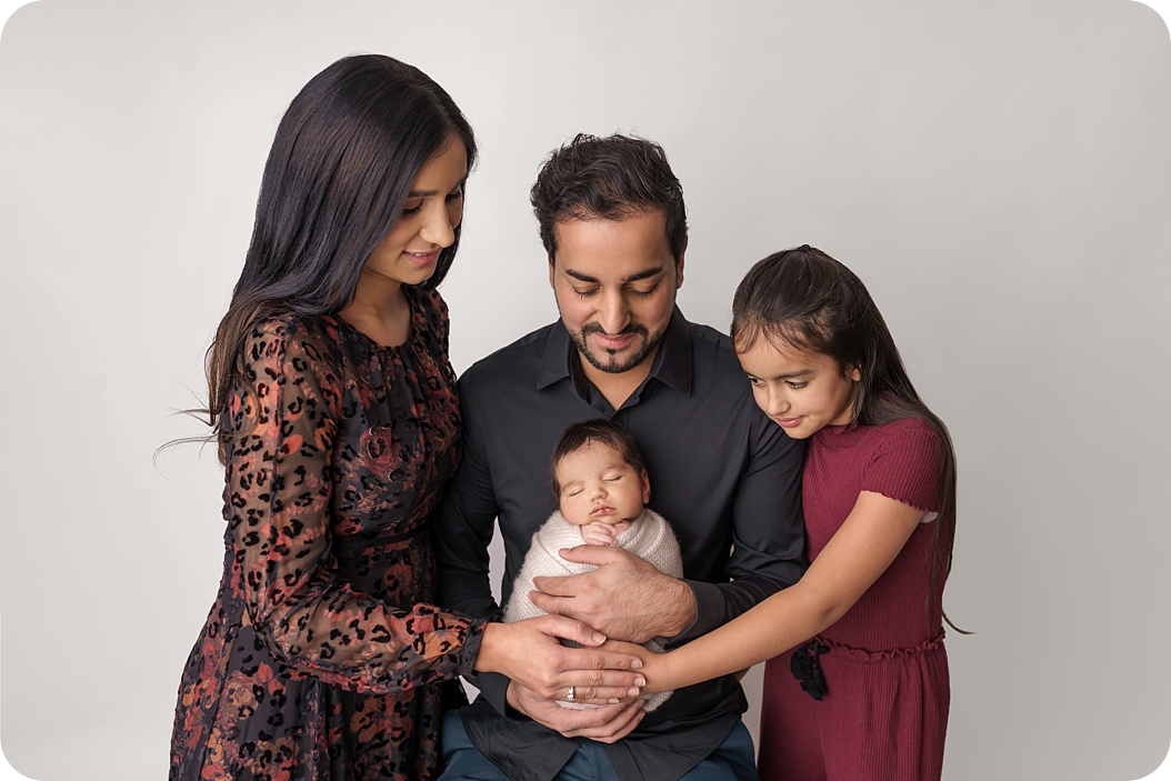 family holds newborn baby boy during Newborn Portraits in Utah Studio