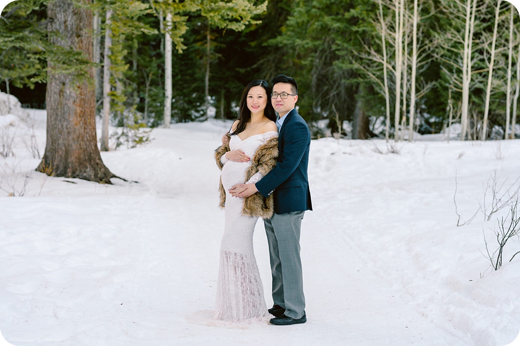 mom and dad pose in snow during Winter Maternity Portraits in Utah with Beka Price Photography