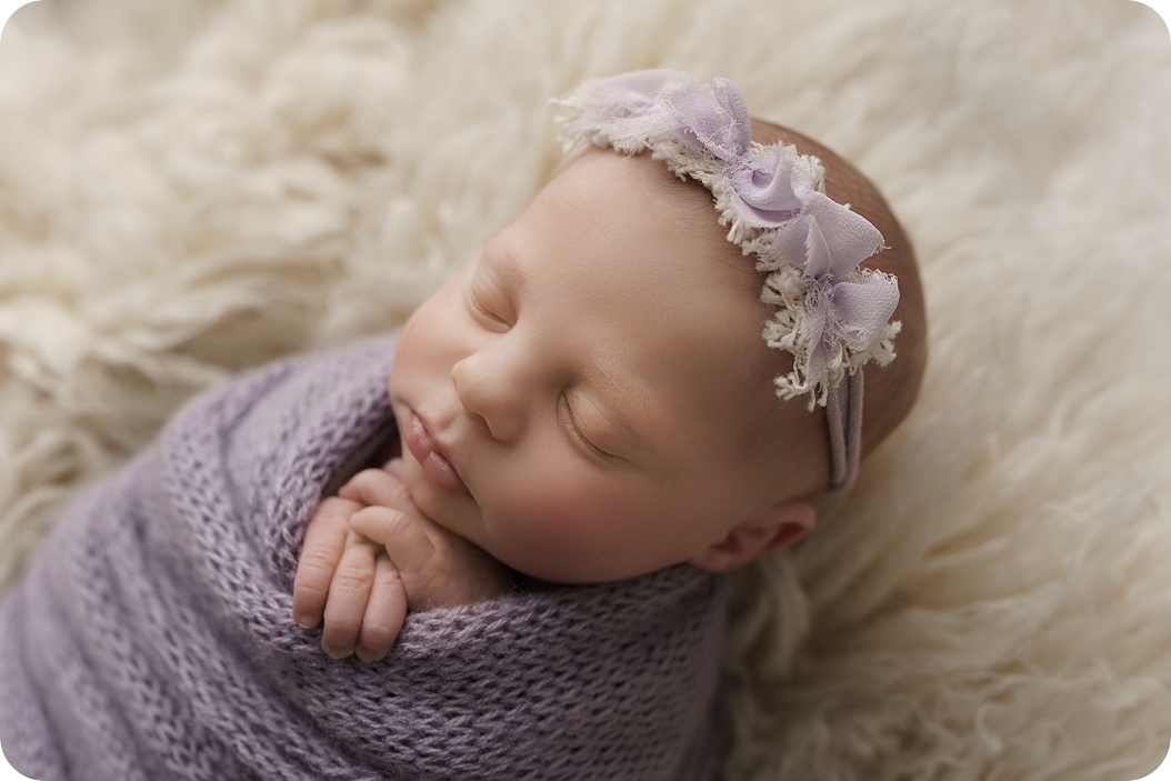 baby girl with pastel purple headband sleeps during Utah newborn session