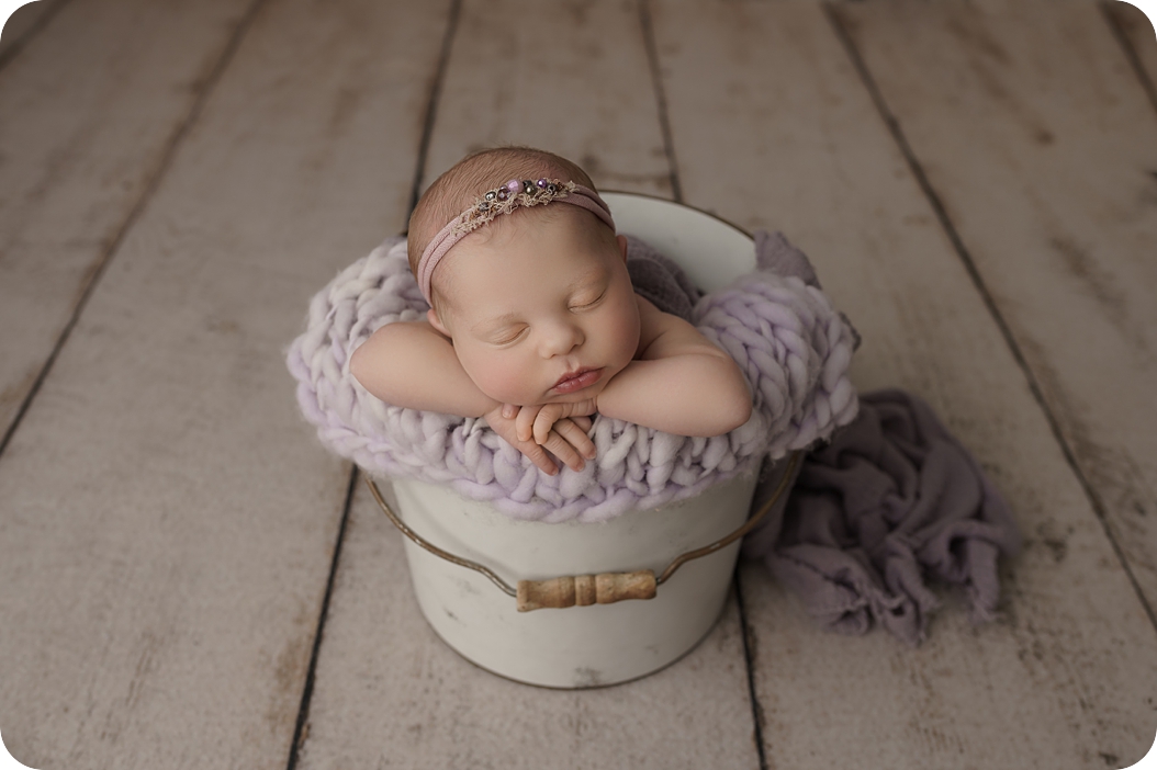 baby sleeps in white bucket and purple blanket during Utah newborn session with Beka Price Photography