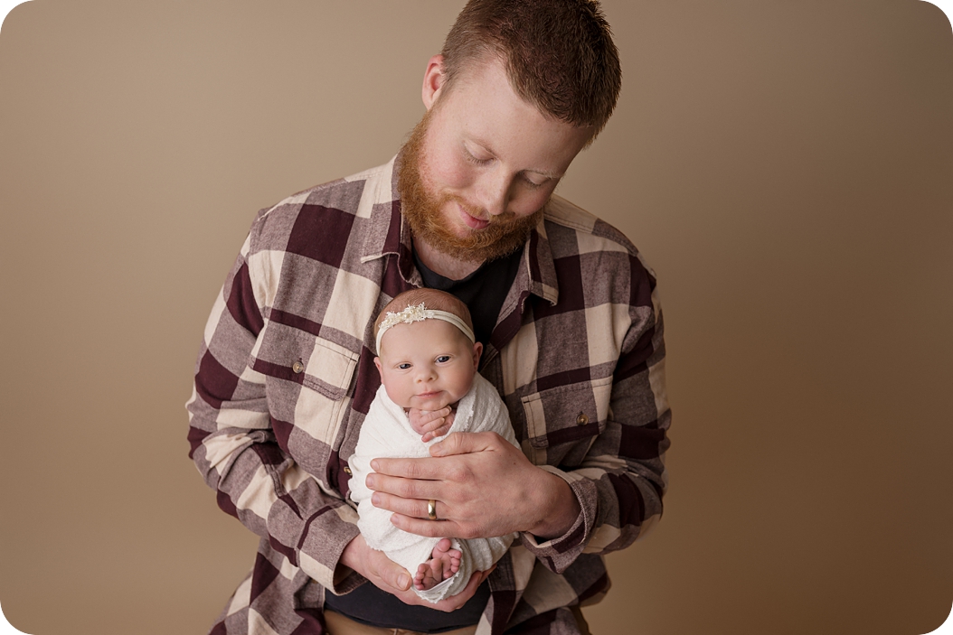 Utah newborn session for baby girl being held by father 