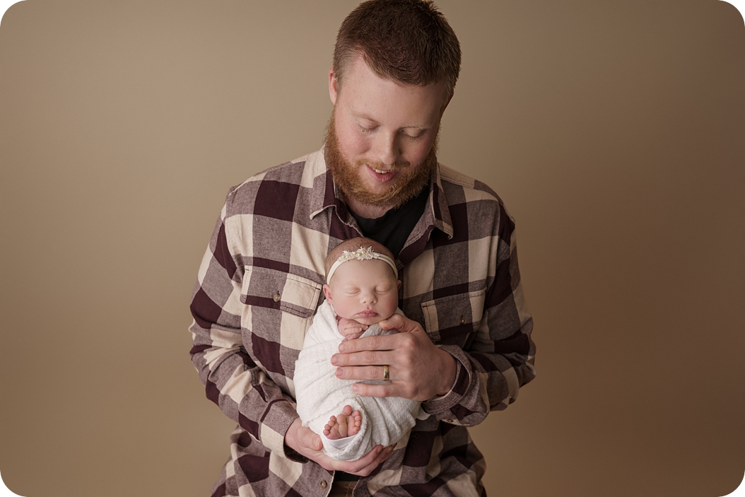 dad holds baby girl in ivory wrap photographed by UT newborn photographer Beka Price Photography 