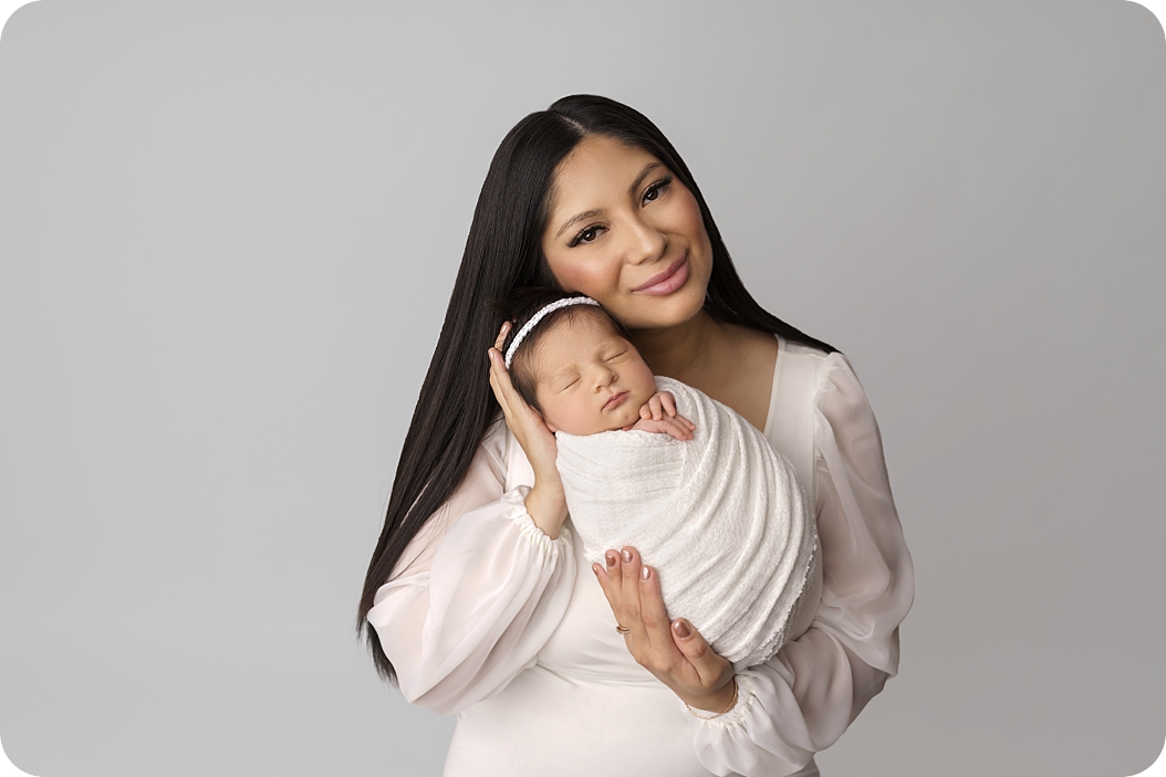 mom holds baby girl in white wrap during Utah newborn session