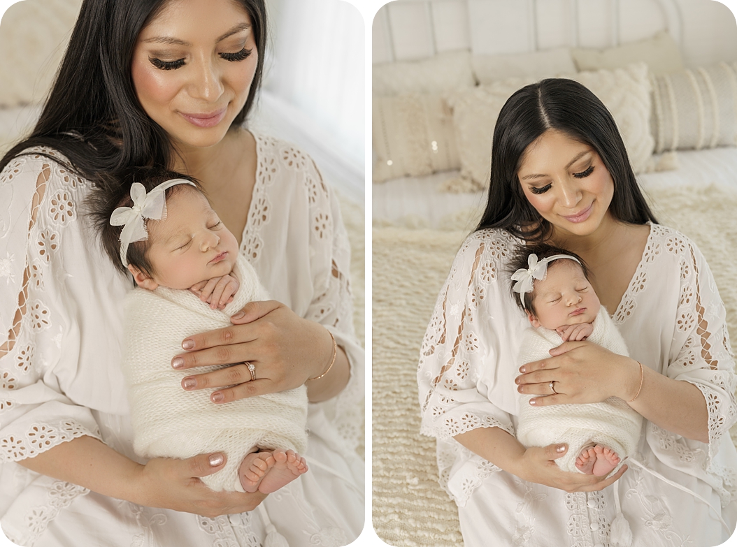 mom holds baby girl on bed during studio newborn session