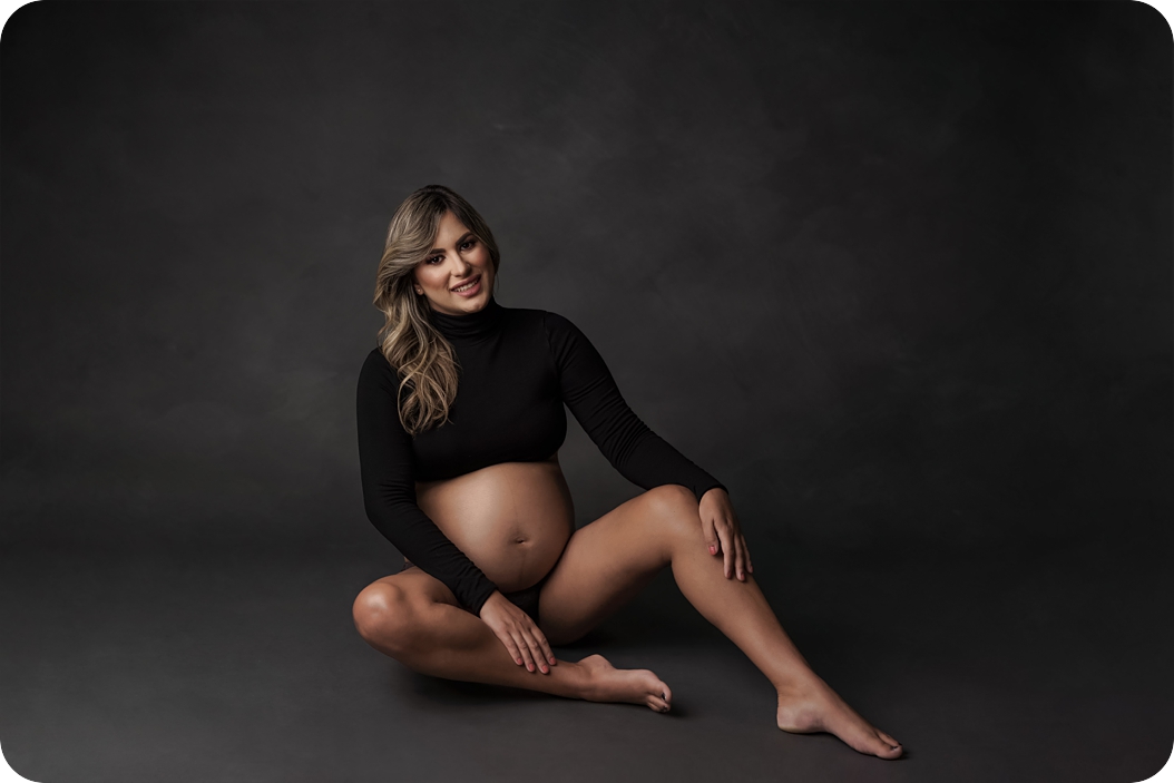 expectant mother in halter top sits on studio floor during Maternity Session 