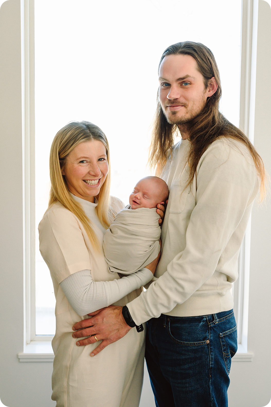 parents hold baby girl in window during Lifestyle Newborn Session in Park City
