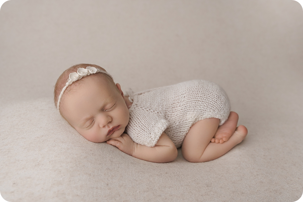 baby sleeps in knit outfit during studio newborn photos in Utah