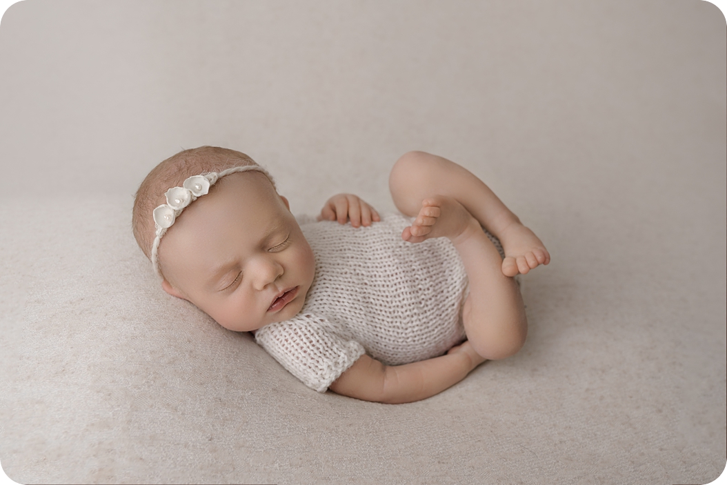 baby girl in cream outfit sleeps during Utah newborn photos 