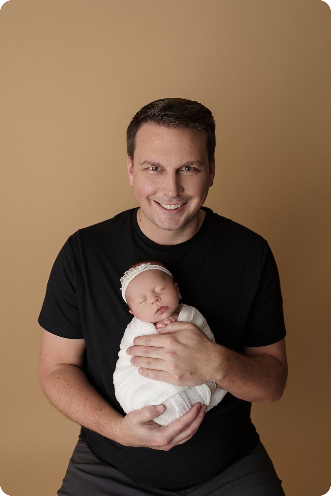 dad holds newborn baby girl during studio newborn session with Beka Price Photography 