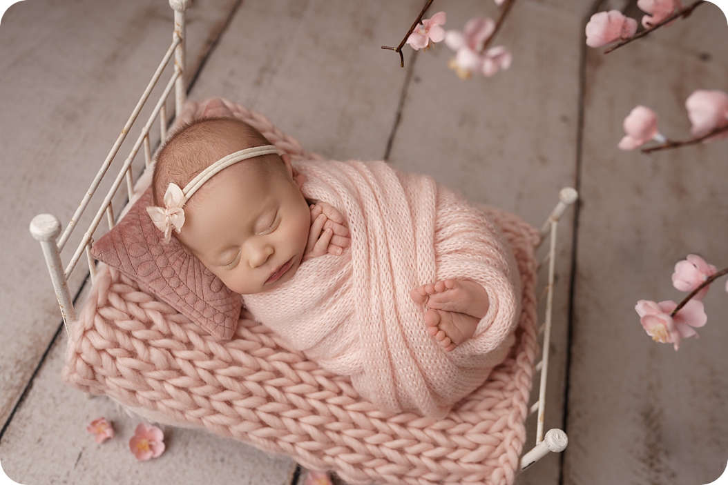 baby girl sleeps on knit blanket during spring studio newborn session