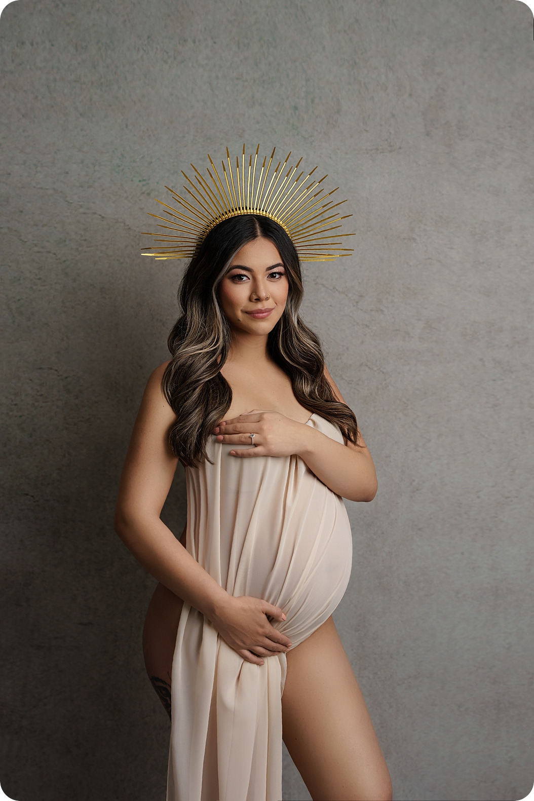 pregnant woman wears crown with gold spikes during fashion maternity photos in Utah 