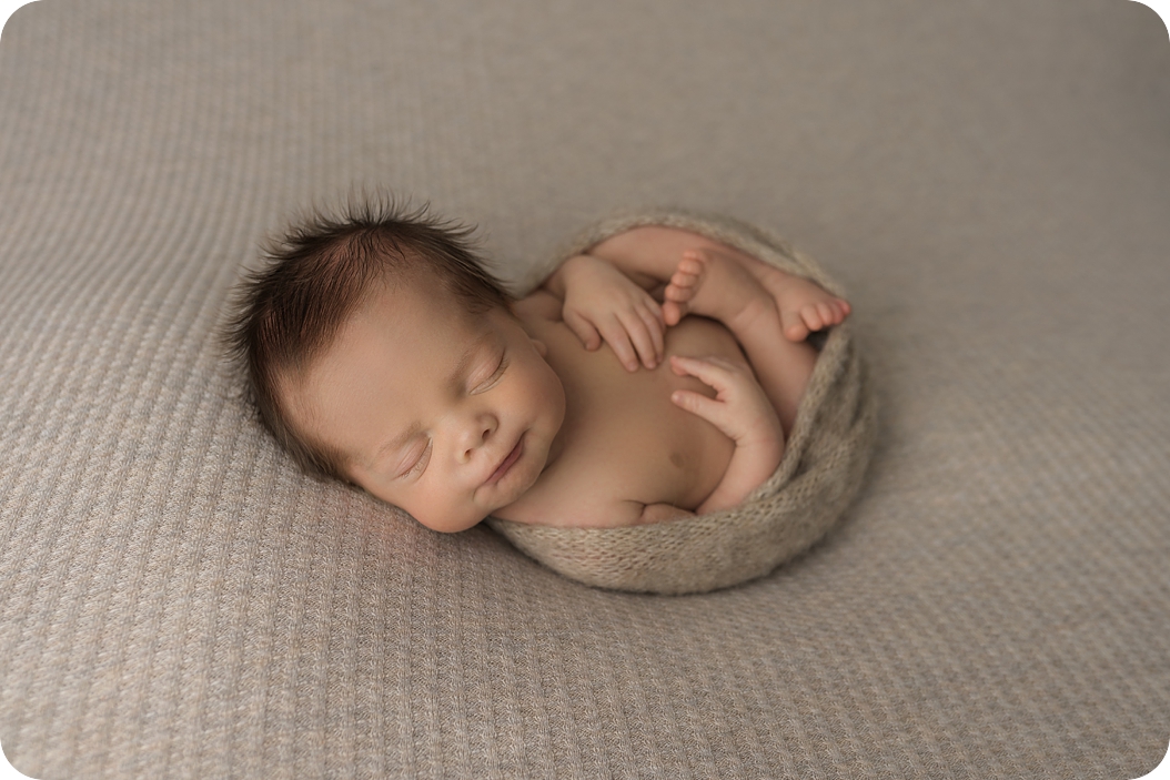 baby boy sleeps curled up during Utah newborn photos 