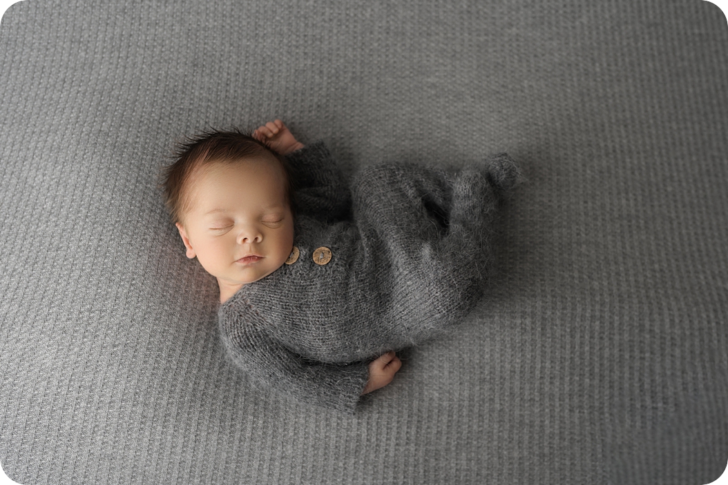 baby sleeps in grey onesie during Utah newborn photos 