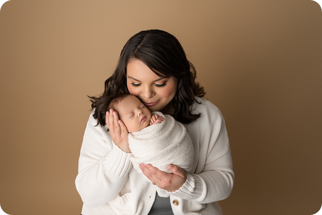 mom holds baby during newborn portraits in Utah studio 