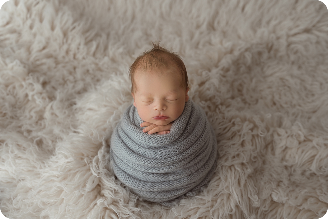 baby boy in grey wrap sleeps during UT newborn photos 