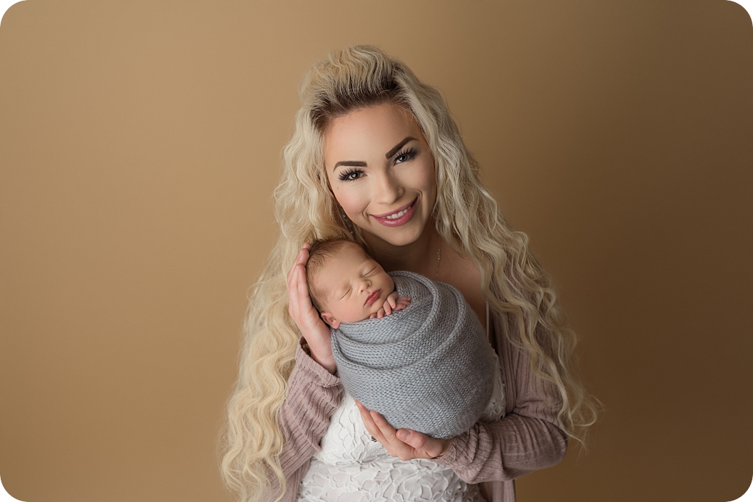 mom holds baby boy during Utah newborn photos in studio 