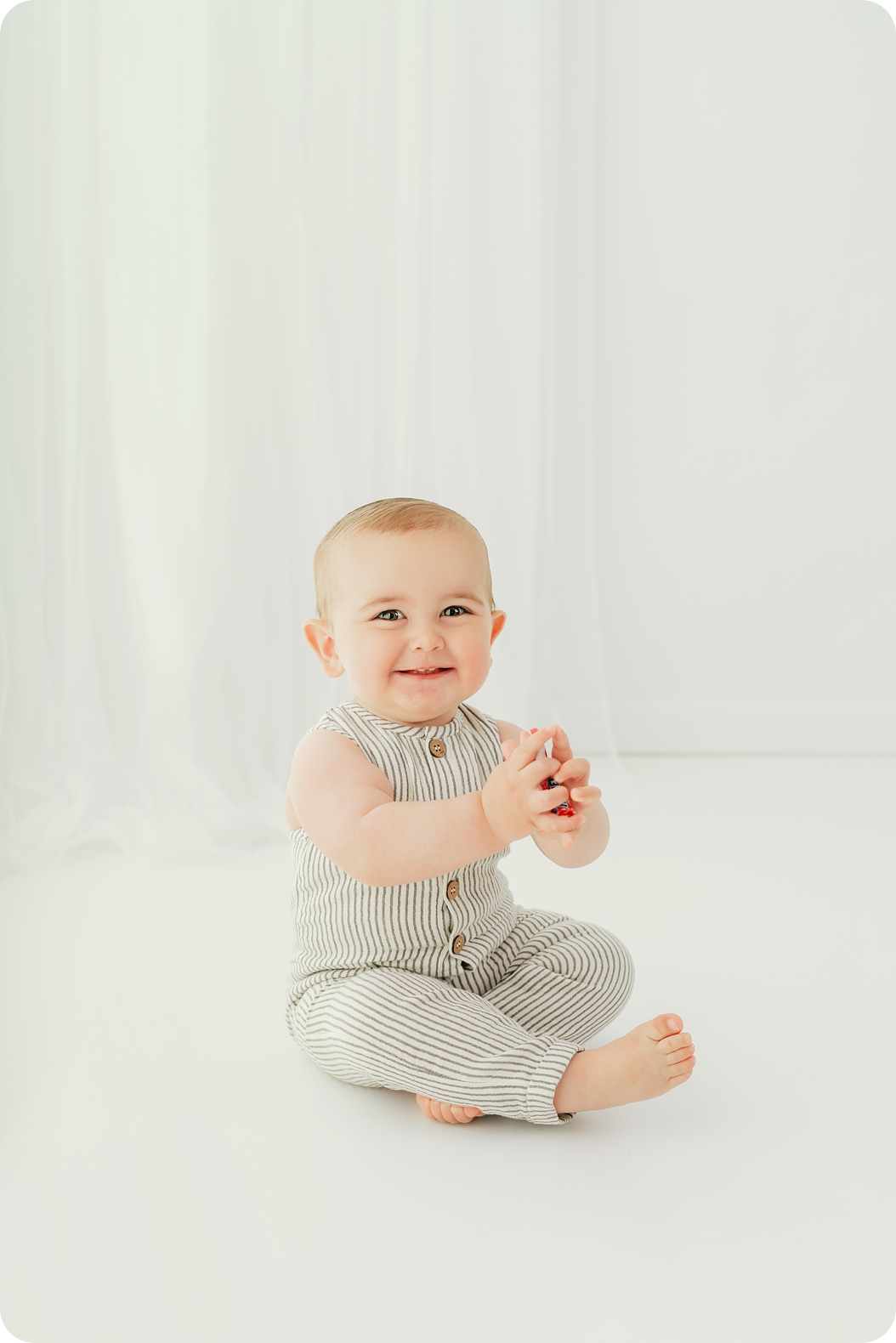 baby plays with candy in studio during birthday photos 