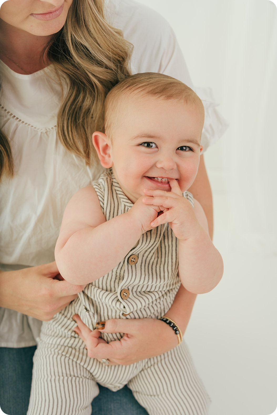 baby chews on finger during Utah birthday portraits