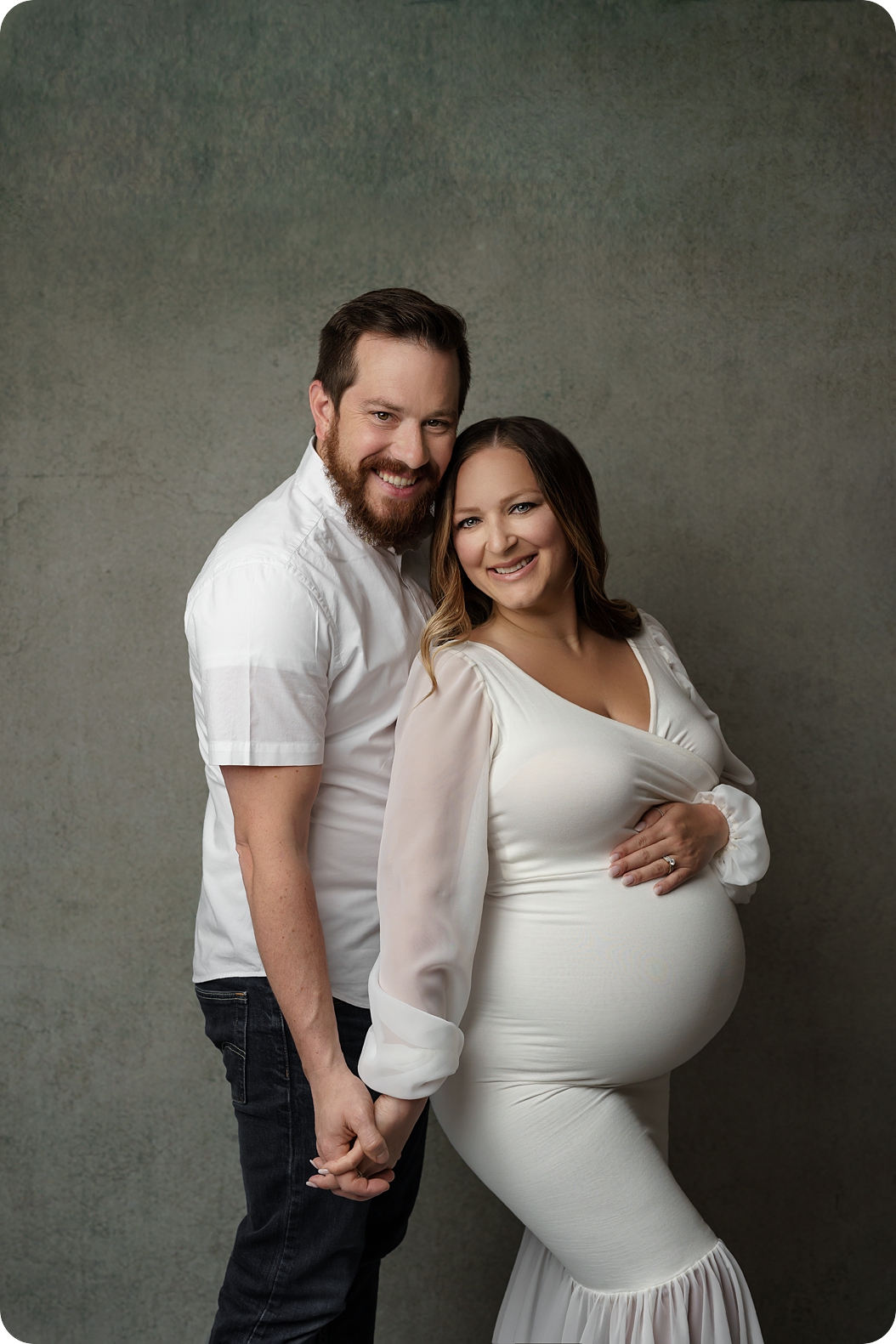 expecting parents pose together during classic studio maternity session with Beka Price Photography