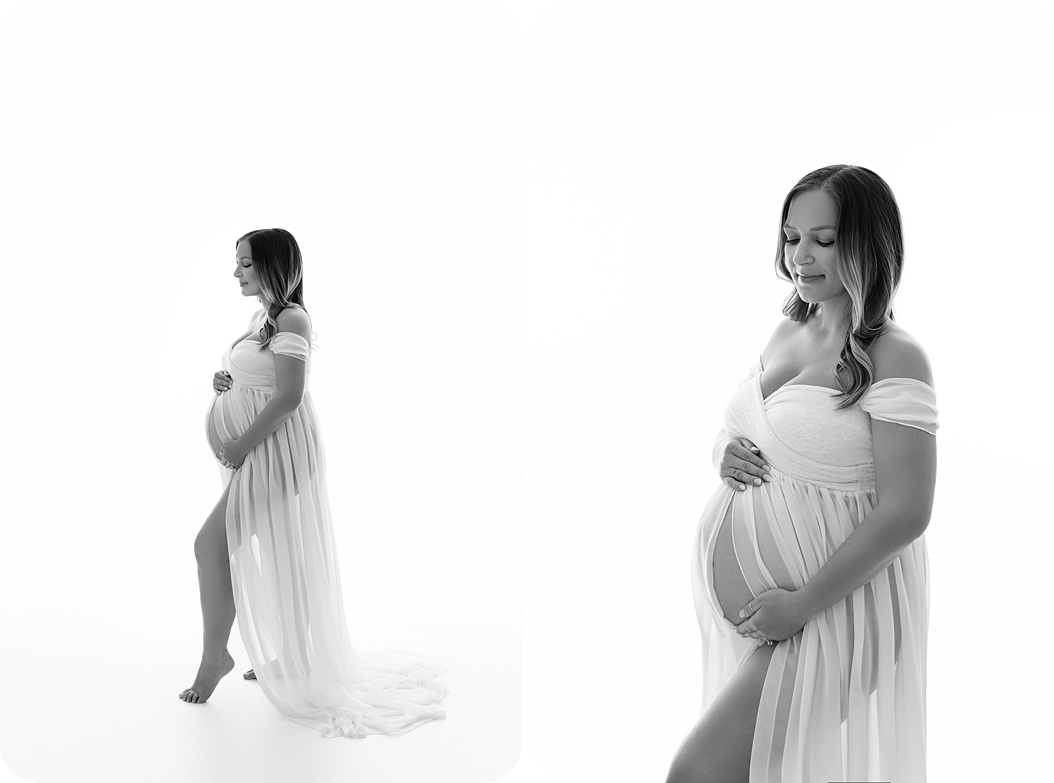 mom in white gown holds belly during classic studio maternity session 