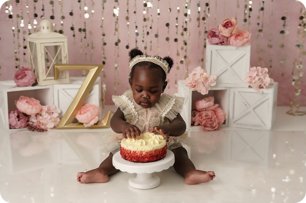 baby plays with red velvet cake during Blush and Gold Cake Smash with Beka Price Photography 
