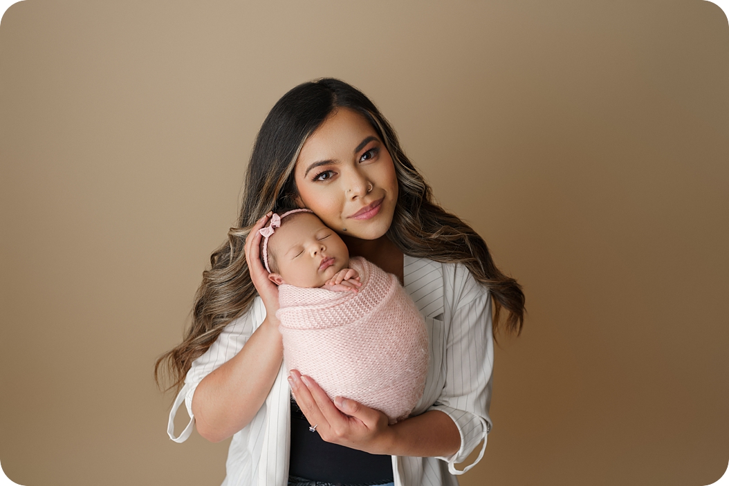 mom and baby girl snuggle during studio newborn session in Holladay UT