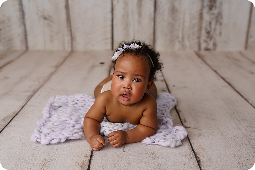 baby rolls on purple blanket in Utah studio during milestone photos 