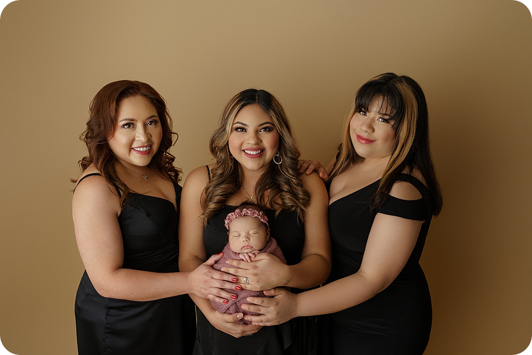 newborn baby held by mother, aunt, and grandma
