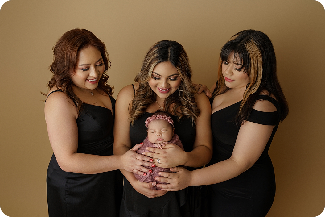 newborn baby held by mother, aunt, and grandma during generational newborn session